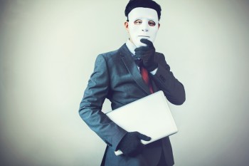 Zdjęcie ilustracyjne, które przedstawia postać mężczyzny zakrywającego twarz