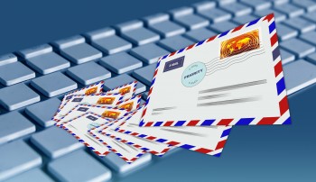 Zdjęcie ilustracyjne- koperty pocztowe wylatujące z klawiatury komputera 
