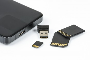 Zdjęcie ilustracyjne cyfrowych nośników pamięci- dysk zewnętrzny, karty SD, karty mirto SD