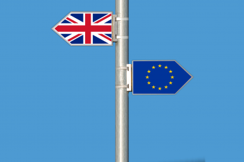Zdjęcie przestawia zawieszone na maszcie flagi Wielkiej Brytanii oraz Unii Europejskiej skierowane w przeciwnych kierunkach 