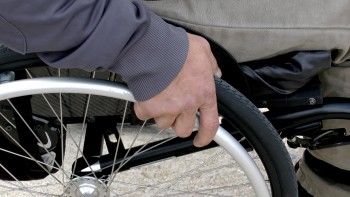Zdjęcie przedstawia osobę poruszającą się na wózku inwalidzkim.